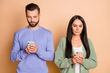 Poster - Photo of sad brunette nice couple look telephone wear sweater isolated on beige color background