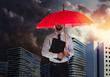 Businessman with umbrella in city center. Insurance concept