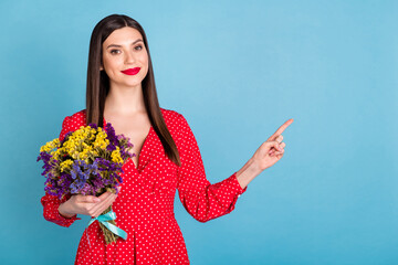 Canvas Print - Portrait of attractive cheery girl holding blossom flowers demonstrating copy space offer advert isolated over bright blue color background