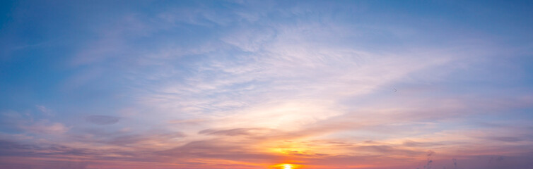 panoramic sunrise with cirrus clouds illuminated by the rays of the sun