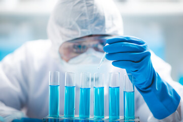 Researchers scientist working analysis with blue liquid test tube in the laboratory, chemistry science or medical biology experiment technology, pharmacy development solution