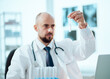 © yurolaitsalbert - young scientist looks at an ampoule with a vaccine.