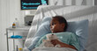 © TommyStockProject - Portrait of sick african girl hugging teddy bear lying in hospital bed