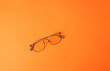 © PhotoJuthamat - Vintage retro black glasses for reading and looking object fashion isolated on orange background