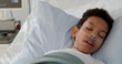 © TommyStockProject - Close up of ill african kid having fever sleeping in bed at hospital