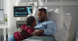 © TommyStockProject - Sick african man lying in hospital bed welcoming and hugging little daughter visiting