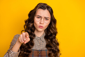 Sticker - Portrait of attractive gloomy sullen smart wavy-haired girl in checked uniform pointing at you isolated over bright yellow color background