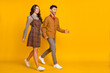 © deagreez - Full size photo of man and woman walk empty space wear plaid dress pants bowtie jumper isolated on yellow color background