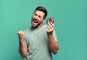 young handsome blond man with a chocolate donut. breakfast concept