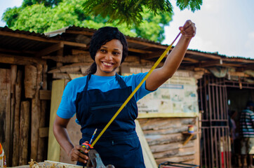 young pretty african female carpenter feeling as she is working in the store