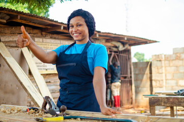 young pretty african female carpenter feeling excited as she did thumbs up