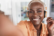 Cheerful african senior woman listening music with headphones while taking a selfie