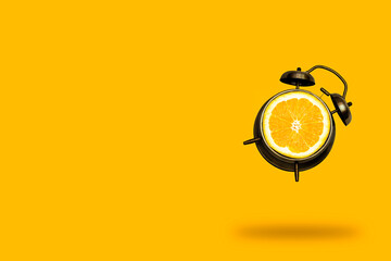 creative art collage flying alarm clock with orange fruit slice on a orange background, summer bright poster