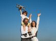 © Volodymyr - Boy with toy airplane on fathers shoulders. Family walk outdoor. Motherhood fatherhood. Son dad mother. Young family with child. Kids love. Family day.