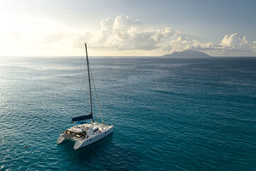 Eco yacht catamaran sailing in ocean at sunset. Aerial view