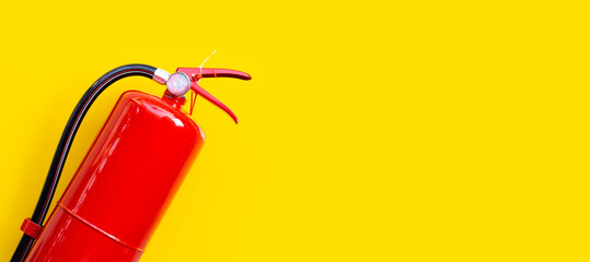 Fire extinguisher on yellow background.