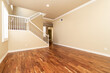 Large empty room with wood floor, molding and windows and stairs. Modern bright room, interiors.