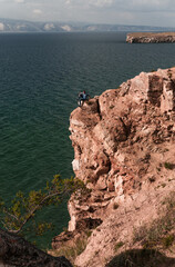 Man on the edge on a high rock on Lake Baikal