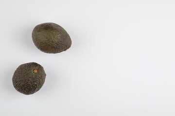 Two fresh healthy brown avocado isolated on white-gray background