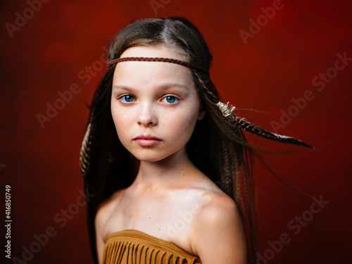 Plakat Wild girl aborigines red background in hair headdress model