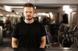 © Nikola Spasenoski - angry man standing and looking at camera in a generic out of focus fitness club.