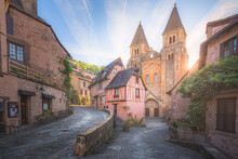 The Quaint And Charming Town Centre Of The  Medieval French Village Conques, Aveyron And Abbey Church Of Sainte-Foy At Sunset Or Sunrise In Occitanie, France.