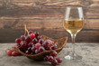© azerbaijan-stockers - Wicker basket of red grapes with glass of wine on marble table