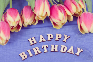  Inscription happy birthday and fresh tulips on boards. Surprise for birthday
