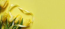 Five Yellow Tulips On A Yellow Background With Yellow Heart Made Of Ribbon