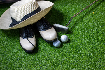 Wall Mural - Golf ball and golf shoes are on green grass background