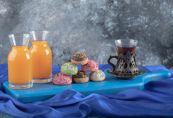 Wall Mural - Fresh juice and homemade cookies with glass of tea on blue wooden board