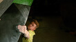 © helivideo - CLOSE UP: Strong man bouldering indoors firmly grips the edge of a volume hold.