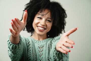 Wall Mural - she pulls her arms out to hug and smiles. portrait of a young woman of Afro appearance ethnic, black curly hair brunette. Clean, even skin of the face. good mood