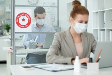 Poster - Elegant man in protective mask networking in office in front of female colleague