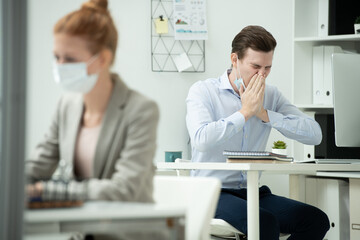 Poster - Young office manager in protective mask covering his nose and mouth by hands