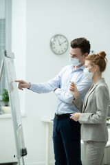 Poster - Young manager in protective mask pointing at whiteboard during presentation
