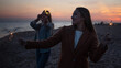 © Ulia Koltyrina - Two cheerful friends on the beach in the evening light sparklers.