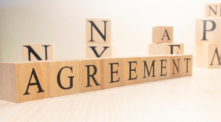 The word agreement is made of wooden cubes. Background from wooden letters.