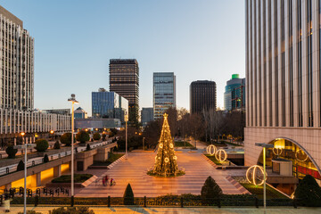 Wall Mural - Wide-angle view of the AZCA business and financial district in Madrid with the traditional illuminated Christmas tree rising in its center.