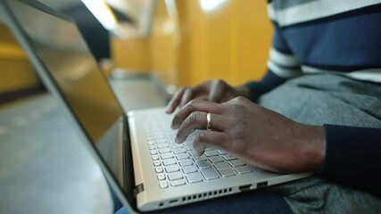 Poster - Black man's hands use laptop while sitting. Pressing the buttons with his fingers, preparing an electronic text document. Camera movement.