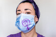 © AliciaFdez - Retrato en primer plano de una mujer joven con una mascarilla quirúrgica para el coronavirus con el símbolo de la mujer. Concepto de Día Internacional de la Mujer en tiempos de pandemia. Feminismo 8M