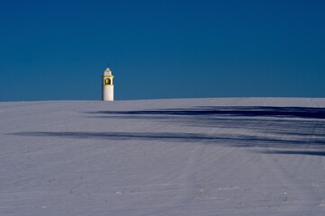 small chapel on a snowy hill, blue sky