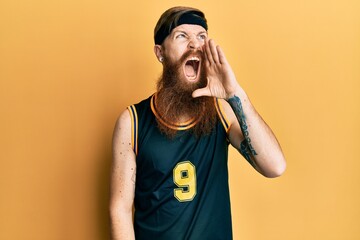 Poster - Redhead man with long beard wearing basketball uniform shouting and screaming loud to side with hand on mouth. communication concept.