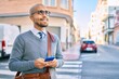 © Krakenimages.com - Young african american businessman smiling happy using smartphone at the city.