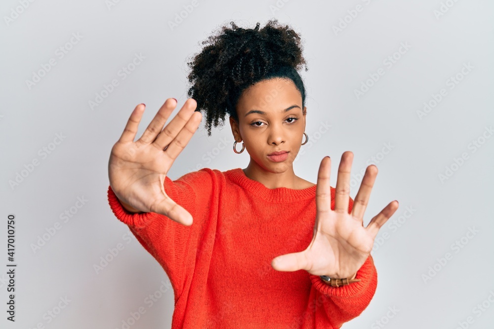 Young african american girl wearing casual clothes doing frame using hands palms and fingers, camera perspective