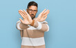 Handsome man with beard wearing casual clothes and glasses rejection expression crossing arms and palms doing negative sign, angry face