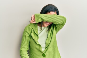 Wall Mural - Young brunette woman wearing casual clothes covering eyes with arm smiling cheerful and funny. blind concept.