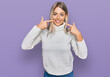 © Krakenimages.com - Beautiful blonde woman wearing casual turtleneck sweater smiling cheerful showing and pointing with fingers teeth and mouth. dental health concept.