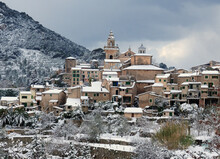 View To The Historic Village Valldemossa And Its Charterhouse Within A Snowy Landscape In The Tramuntana Mountains On Balearic Island Mallorca On A Sunny Winter Day With A Few Clouds In The Sky