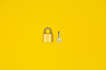 Key and padlock, lock on yellow background